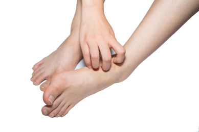 一个人脚部瘙痒难耐疑似得了灰指甲脚气香港脚正在挠痒痒解痒棚拍白色背景