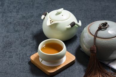 深色桌面一角摆放的茶壶茶杯及茶叶罐