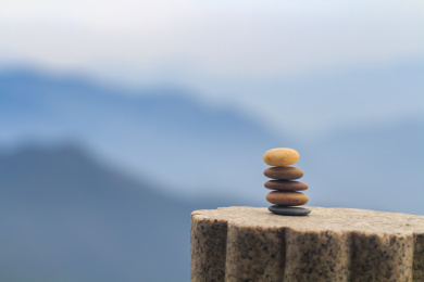 山上石柱上堆叠的五颗颜色不同的鹅卵石