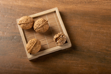 木纹上的竹制簸箕里的核桃