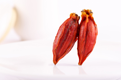 两个红色的栀子果实立在桌面上