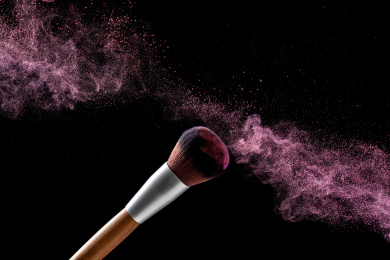 化妆刷在黑色背景中甩动，扬起紫红的妆粉