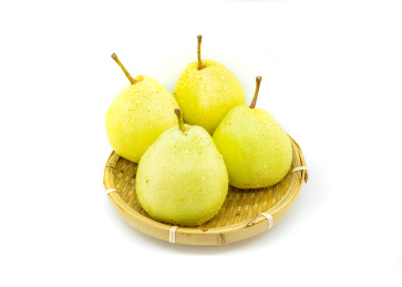 白色背景果篮里的一篮黄色鸭梨