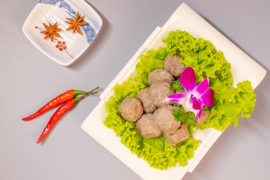 放在白色瓷盘生菜叶上的撒尿牛丸