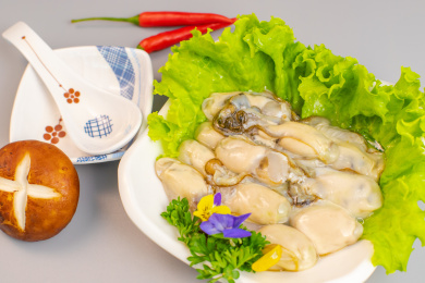 放在白色瓷盘生菜叶上的蛤蜊肉