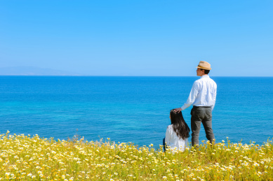 亚裔情侣在希腊圣托里尼岛的春天的花丛中玩耍