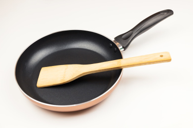 纯色背景中的烹饪厨具平底锅与竹铲