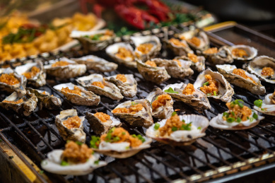 很多个放在烤架上正在烤制的生蚝