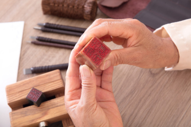 篆刻艺术家手拿石质印章仔细观察