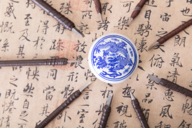 俯视拍摄中国书法作品上被众多钢制刻刀围绕的一盒印泥