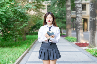 一个青春清纯的美女大学生在校园内教育学习抱着书本准备去上课自习复习概念