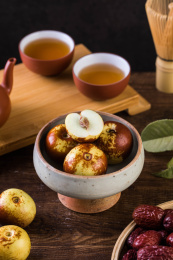 用复古高脚碗装着的冬枣，旁边还摆放着茶壶和茶杯