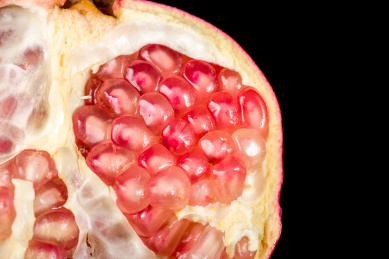 在黑色的背景上一个切开的石榴的特写