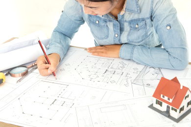 建筑结构设计师正对着大量的图纸认真工作