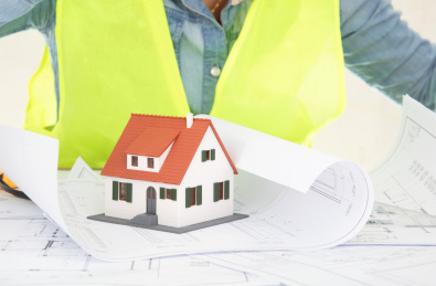 建筑工程师面对着图纸上的房子模型