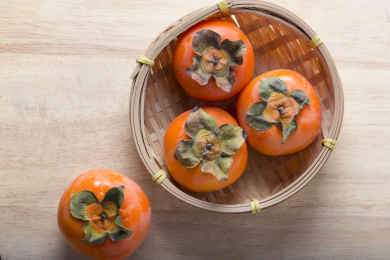 放在光亮木板上的多个新鲜成熟的柿子俯拍特写