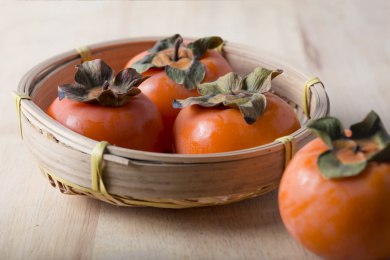 放在光亮木板上的多个新鲜成熟的柿子俯拍特写