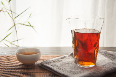 自然光线逆光茶杯里和分茶器里的普洱茶熟茶
