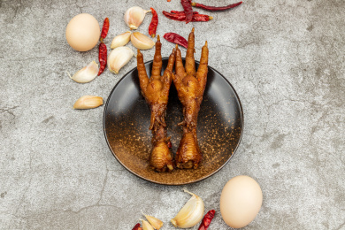 水泥背景上圆碟子里的卤凤爪