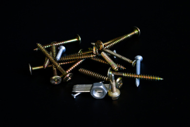 纯黑色背景板上的不锈钢螺丝螺母