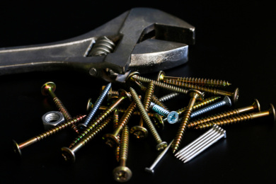 纯黑色背景板上的不锈钢螺丝螺母