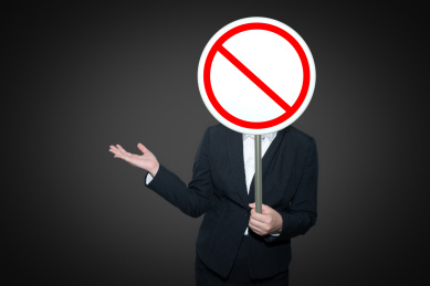 一个人拿着一个红色圆形禁止标识交通指示牌手里展示着标识警醒警告提示提醒概念