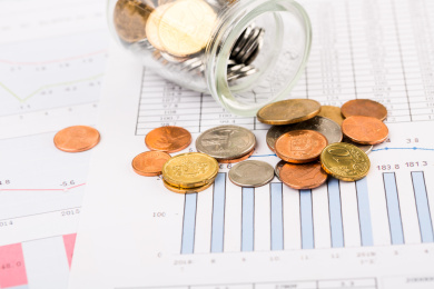 硬币在玻璃瓶中和商业数据图表背景