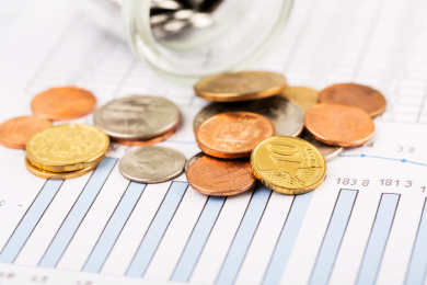 硬币在玻璃瓶中和商业数据图表背景