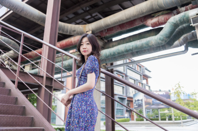 秋天蓝天白云下北京798艺术区的钢铁建筑旁的美女