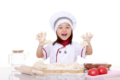 穿着厨师服的小女孩做面食手工是开心的伸着双手