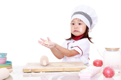 穿着厨师服的小女孩做面食手工
