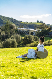 坐在山坡草坪上的阳光女孩