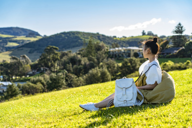 坐在山坡草坪上的阳光女孩