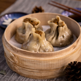 一份糯米烧麦放在木质蒸笼中