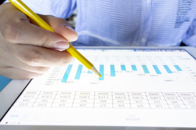 手里拿着笔在分析数据图表