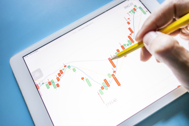 手里拿着笔在分析数据图表