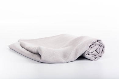 白色背景下中性灰纯色成卷棉麻布匹