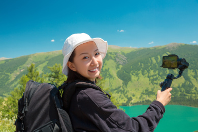 一位美丽的中国女孩用手持稳定器设备记录旅行视频