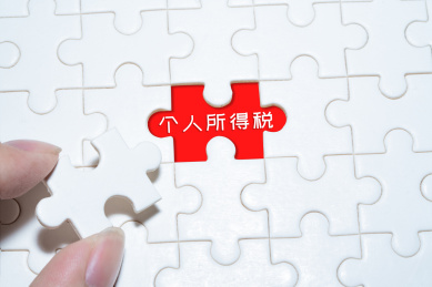 人手拿着拼图贴图拼块上面写着收税纳税和钥匙锁表示个税偷税漏税纳税概念