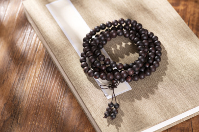 窗影下的木桌面上摆放着108颗降真香手串