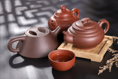 窗影下的黑色桌面上摆放着传统茶具紫砂壶及紫砂杯