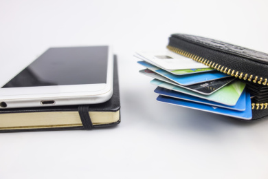 白色背景中放着手机笔记本和钱包