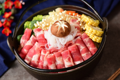 放在黑色火锅里的肥牛卷和蔬菜食材