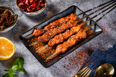 深色背景下放在盘子里的烤羊肉串