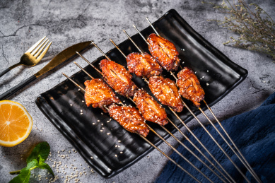 深色背景下放在盘子里的烤鸡翅