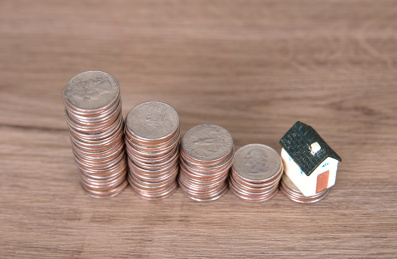 美元硬币和房屋模型组成的房价走低概念