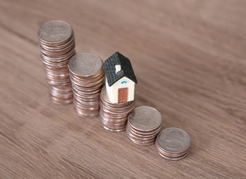 房屋模型和美元硬币组成的房价行情走势