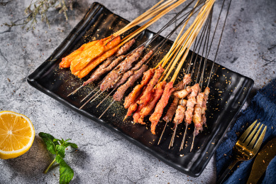 深色背景下放在盘子里的烤肉串儿