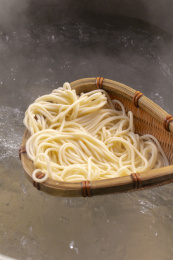 竹箕在大锅中捞起热腾腾的面