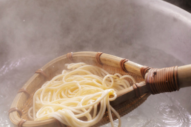 竹箕在大锅中捞起热腾腾的面